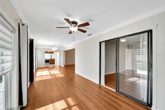 unfurnished living room featuring ceiling fan, light wood-type flooring, and crown molding