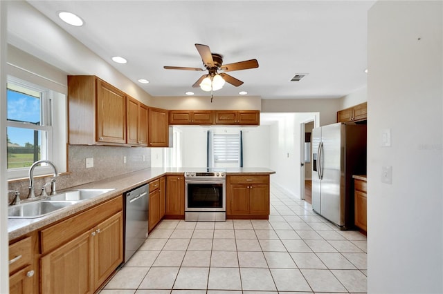 kitchen featuring kitchen peninsula, appliances with stainless steel finishes, ceiling fan, sink, and light tile patterned floors