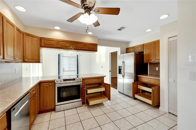 kitchen featuring ceiling fan, tasteful backsplash, kitchen peninsula, light tile patterned floors, and appliances with stainless steel finishes