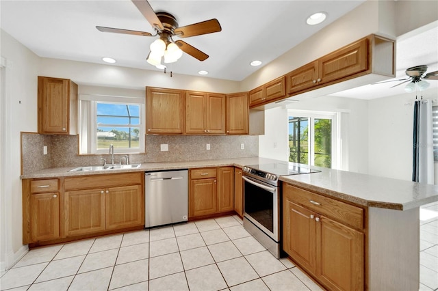 kitchen featuring sink, ceiling fan, tasteful backsplash, kitchen peninsula, and stainless steel appliances