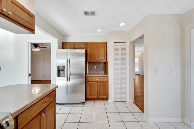 kitchen featuring decorative backsplash, stainless steel fridge with ice dispenser, light tile patterned floors, and ceiling fan