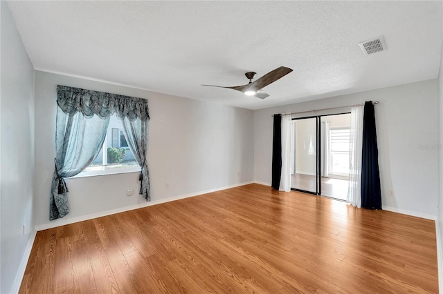 unfurnished room featuring wood-type flooring, a textured ceiling, and ceiling fan