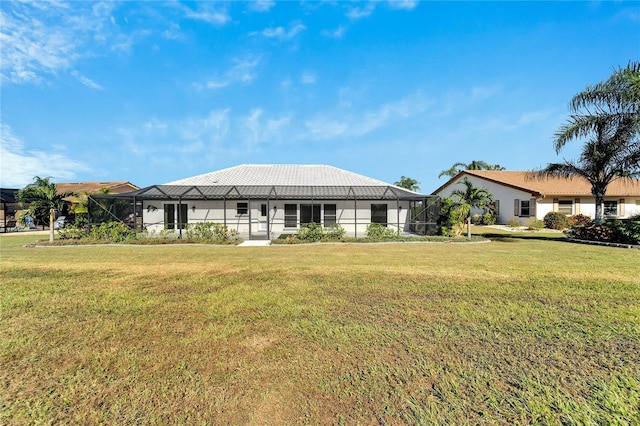 rear view of property featuring a lanai and a yard