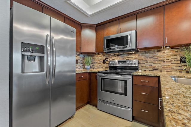 kitchen featuring light stone countertops, sink, appliances with stainless steel finishes, and tasteful backsplash