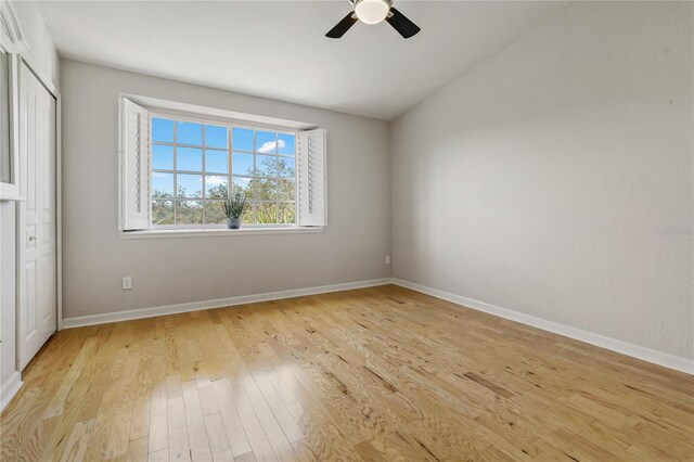 unfurnished bedroom featuring ceiling fan, light hardwood / wood-style floors, and vaulted ceiling