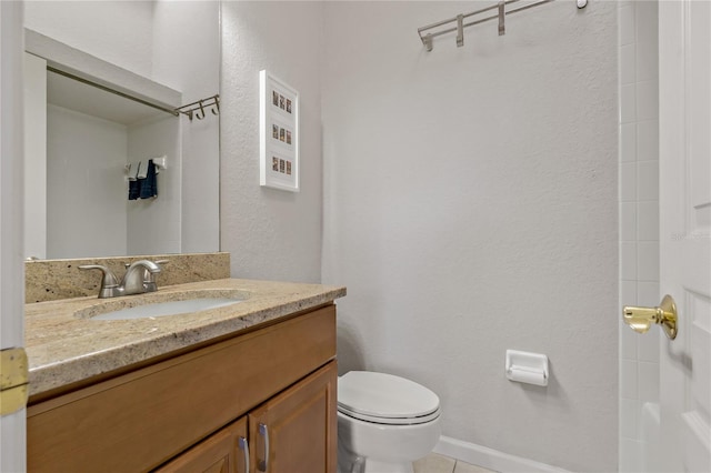 bathroom featuring tile patterned flooring, vanity, and toilet