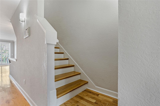 stairs featuring hardwood / wood-style flooring