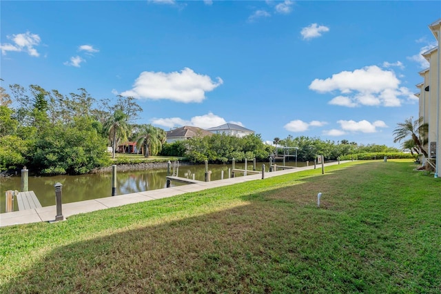 exterior space featuring a lawn, a water view, and a boat dock