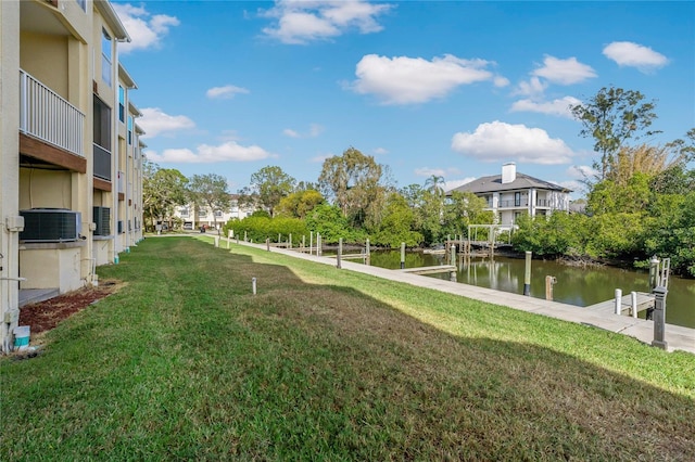 surrounding community featuring a lawn, a dock, and a water view