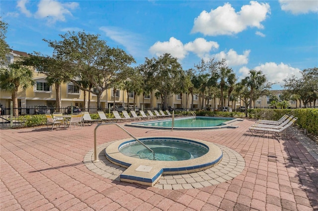 view of swimming pool featuring a hot tub