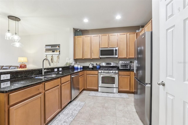 kitchen with sink, hanging light fixtures, dark stone counters, light tile patterned flooring, and appliances with stainless steel finishes