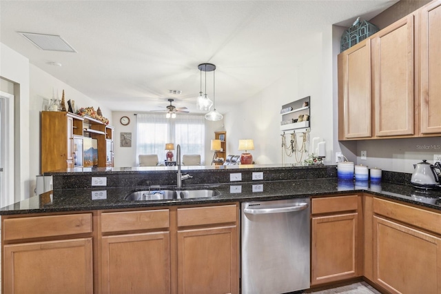 kitchen with pendant lighting, stainless steel dishwasher, dark stone countertops, and sink