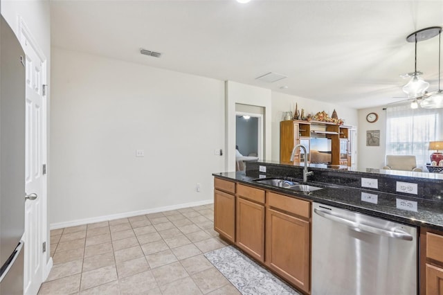 kitchen with stainless steel dishwasher, dark stone counters, ceiling fan, sink, and light tile patterned flooring