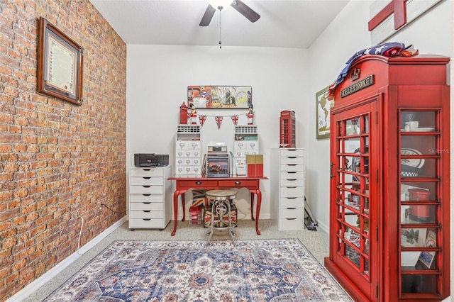 office space featuring ceiling fan and brick wall