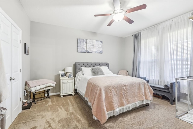 carpeted bedroom with ceiling fan and a closet