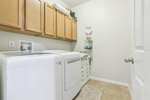 washroom with washing machine and dryer, light tile patterned floors, and cabinets