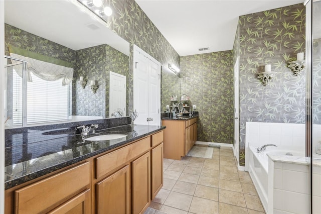 bathroom featuring a tub to relax in, tile patterned flooring, and vanity