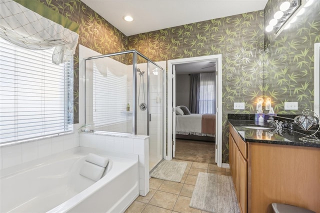 bathroom with tile patterned floors, vanity, shower with separate bathtub, and a wealth of natural light