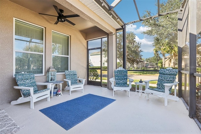 sunroom / solarium featuring ceiling fan and beamed ceiling