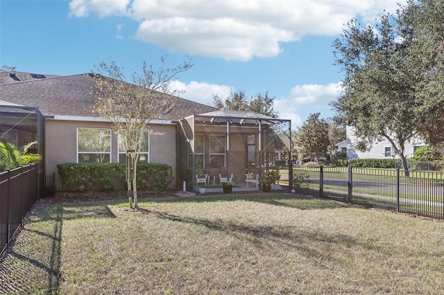 back of house with glass enclosure and a lawn