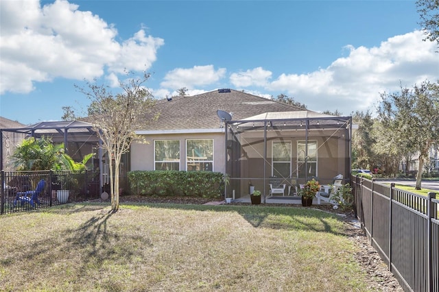 back of house featuring a lawn and a lanai