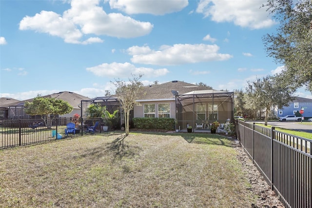 rear view of property featuring a yard and a lanai