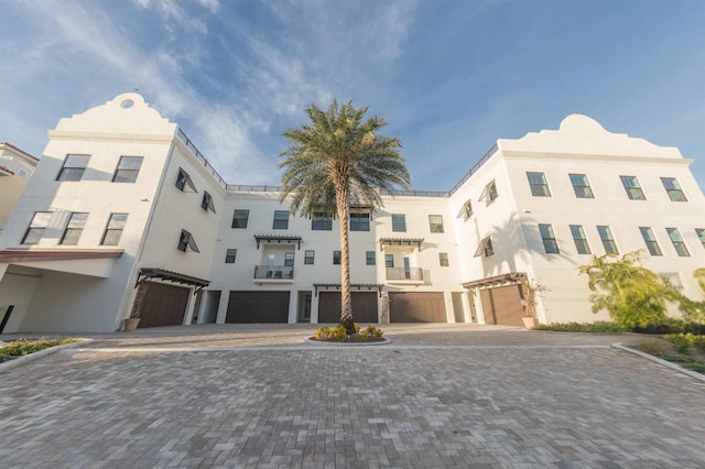 view of property featuring decorative driveway and a garage