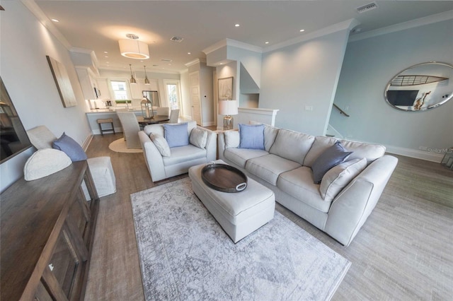 living room with wood-type flooring and crown molding