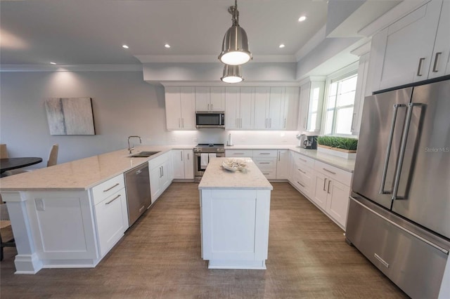 kitchen featuring light stone countertops, white cabinets, a center island, stainless steel appliances, and hanging light fixtures