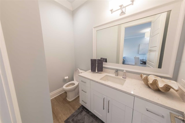 bathroom featuring toilet, vanity, and hardwood / wood-style floors