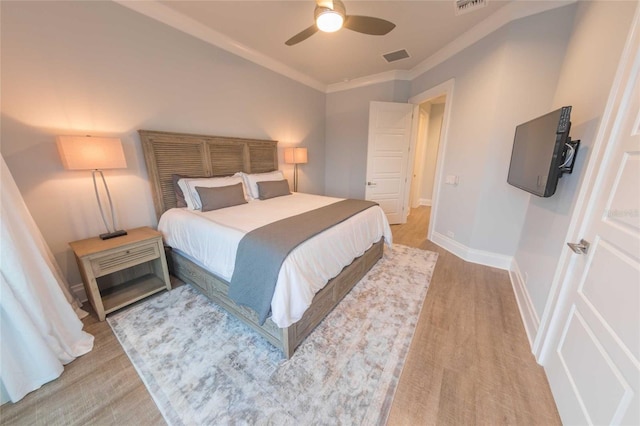 bedroom featuring ceiling fan, crown molding, and light hardwood / wood-style floors