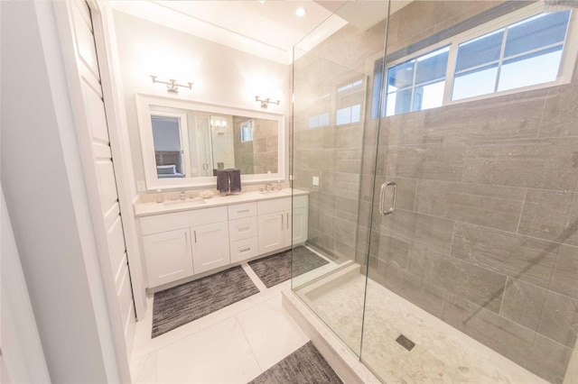 bathroom with a shower with shower door, vanity, and tile patterned flooring