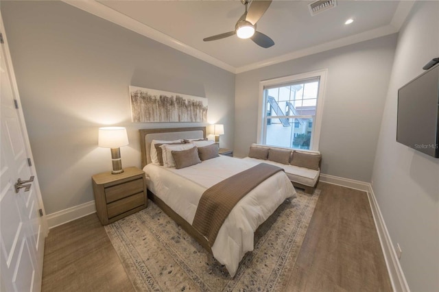 bedroom with ceiling fan, hardwood / wood-style flooring, and crown molding