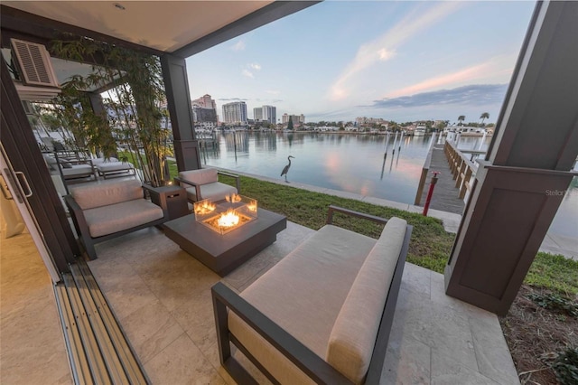 patio terrace at dusk with a water view and an outdoor living space