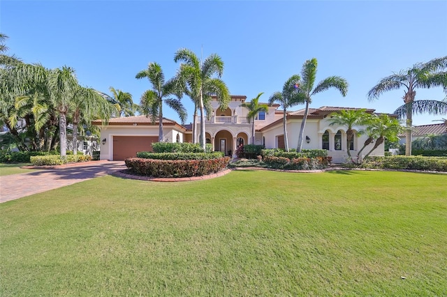 mediterranean / spanish home with a balcony, a front yard, and a garage