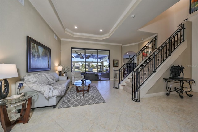 tiled living room featuring a raised ceiling and ornamental molding