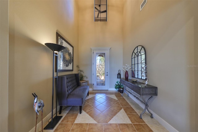 foyer with tile patterned flooring and a towering ceiling