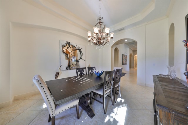 dining room with light tile patterned flooring, ornamental molding, a tray ceiling, and a chandelier