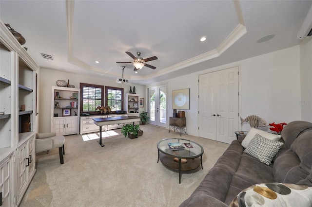 living room with light colored carpet, ornamental molding, a raised ceiling, and french doors