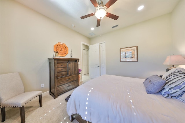 bedroom with ceiling fan, light colored carpet, and a closet