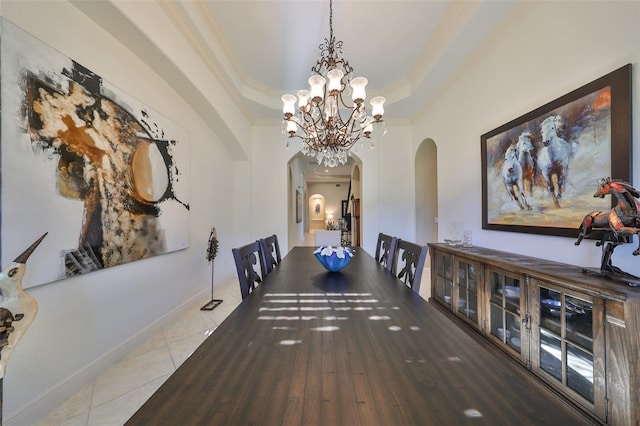 dining area featuring a raised ceiling, tile patterned floors, crown molding, and a chandelier