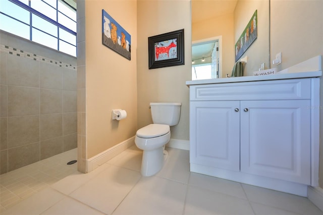 bathroom with a walk in shower, tile patterned flooring, toilet, vanity, and baseboards