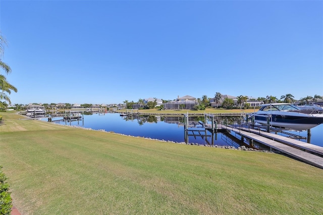 dock area featuring a water view, a lawn, and boat lift