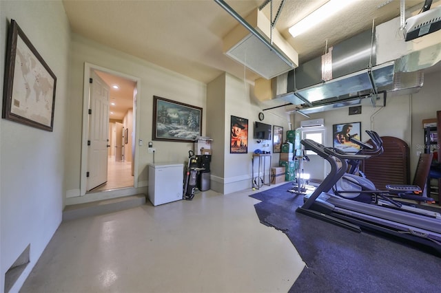 exercise room featuring attic access and baseboards