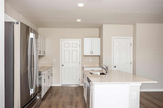 kitchen with white cabinets, appliances with stainless steel finishes, dark hardwood / wood-style floors, and sink