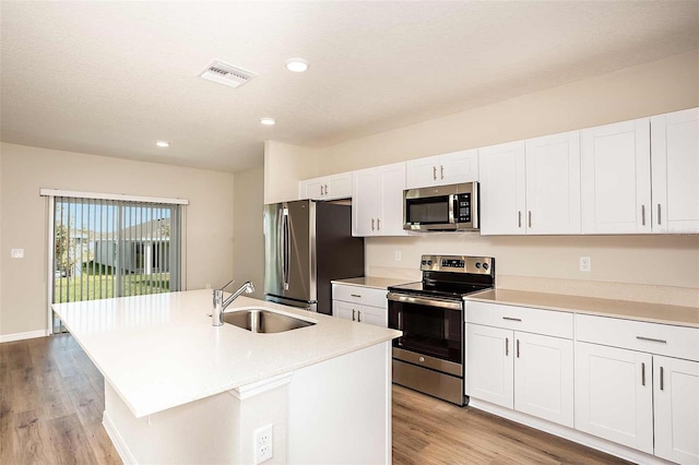 kitchen with a kitchen island with sink, sink, white cabinets, and stainless steel appliances