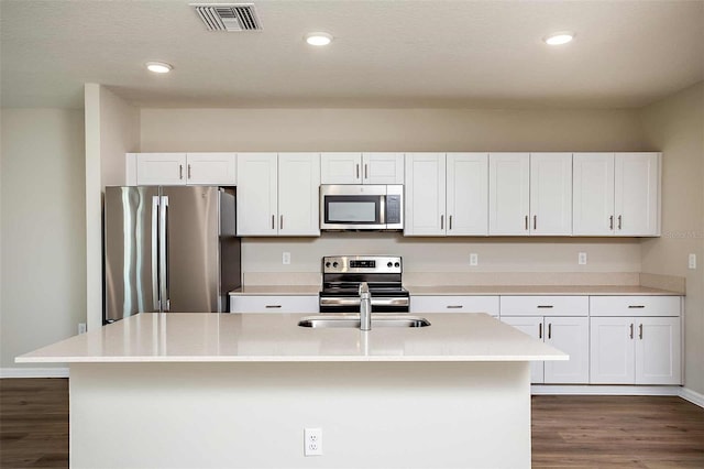 kitchen featuring white cabinets, dark hardwood / wood-style floors, stainless steel appliances, and a kitchen island with sink