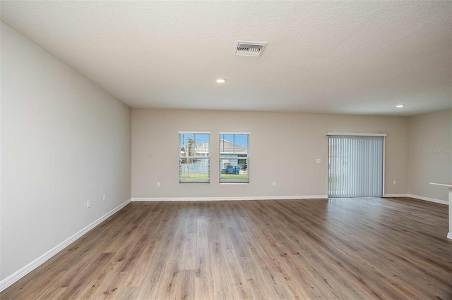 empty room featuring light hardwood / wood-style flooring and a textured ceiling