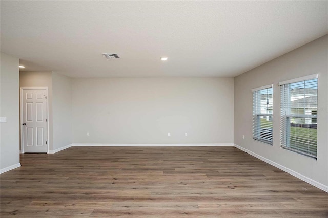 spare room with hardwood / wood-style floors and a textured ceiling