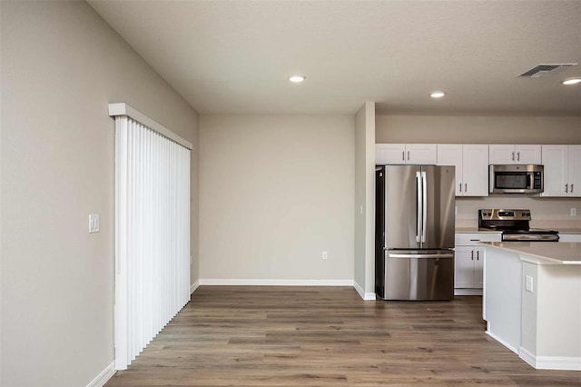 kitchen featuring white cabinets, hardwood / wood-style floors, and stainless steel appliances